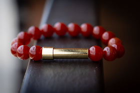 red Carnelian cremation bracelet on a railing for