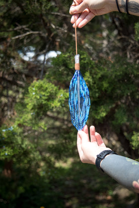 suncatcher glass feather with cremation ash held in hand