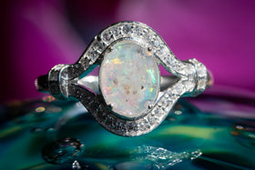 Oval Eye Ring with white opal sitting atop a glass surface. Sterling Silver Ring, Sterling Silver Ring with Zircon, Sterling Silver Ring for Ash, Silver Ring for Cremains, Jewelry for Cremation Ash, Remembrance Jewelry, Silver Remembrance Jewelry