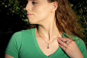 Photo depicts a model wearing the Bedazzled Drop Pendant on chain. The sterling silver pendant is bedazzled with cubic zirconia and filled with a rainbow selection of crushed opal. Sterling Silver Necklace for Cremation Ash, Sterling Silver Necklace for Ash, Sterling Silver Necklace with Zircon, Necklace for Remembrance