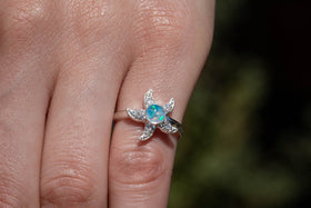 Photo of sterling silver Bedazzled Starfish Ring, with light blue opal, being worn by a model. Sterling Silver Ring for Ash, Sterling Silver and Zircon Ring, Ring for Cremation Ash, Silver Remembrance Jewelry, Jewelry for Ash