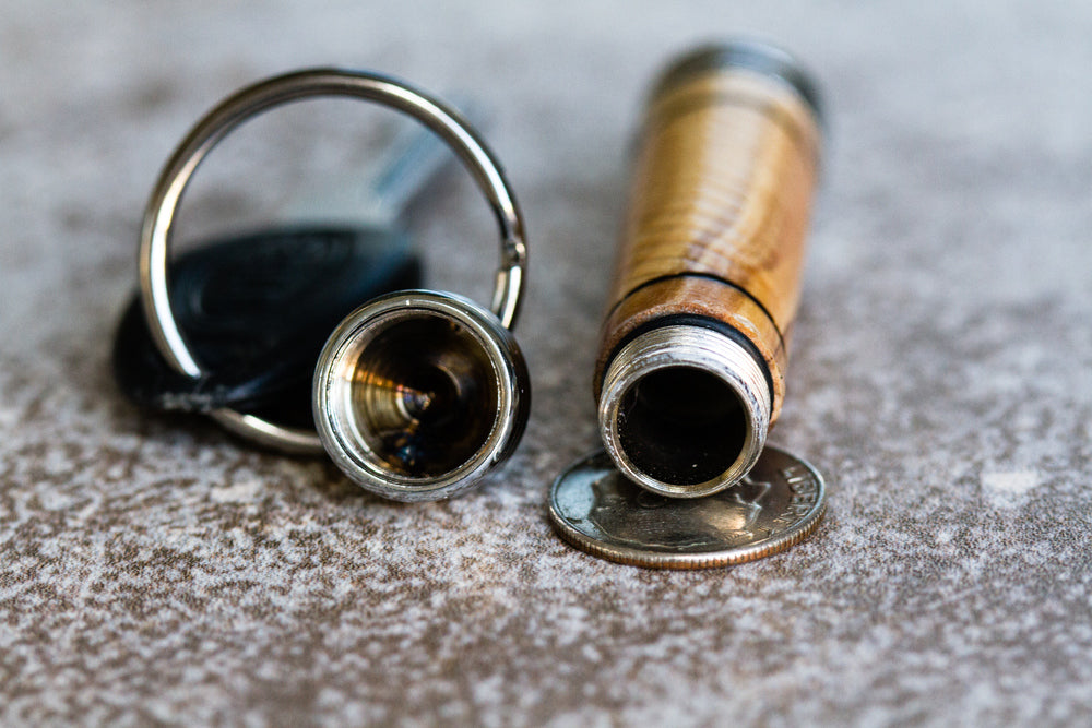 Close up of a corked bottle with its cap removed beside a coin on a textured surface.