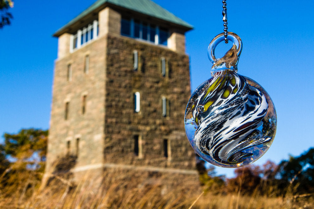 Perkins Memorial Tower with a swirled glass ornament hanging in the foreground against a clear blue sky.