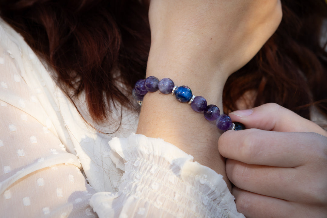Close up of an amethyst bead healing bracelet worn on the wrist with silver spacers