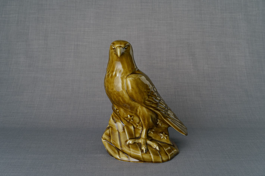 Aquilae ceramic urn featuring a golden eagle perched on a sculpted base.