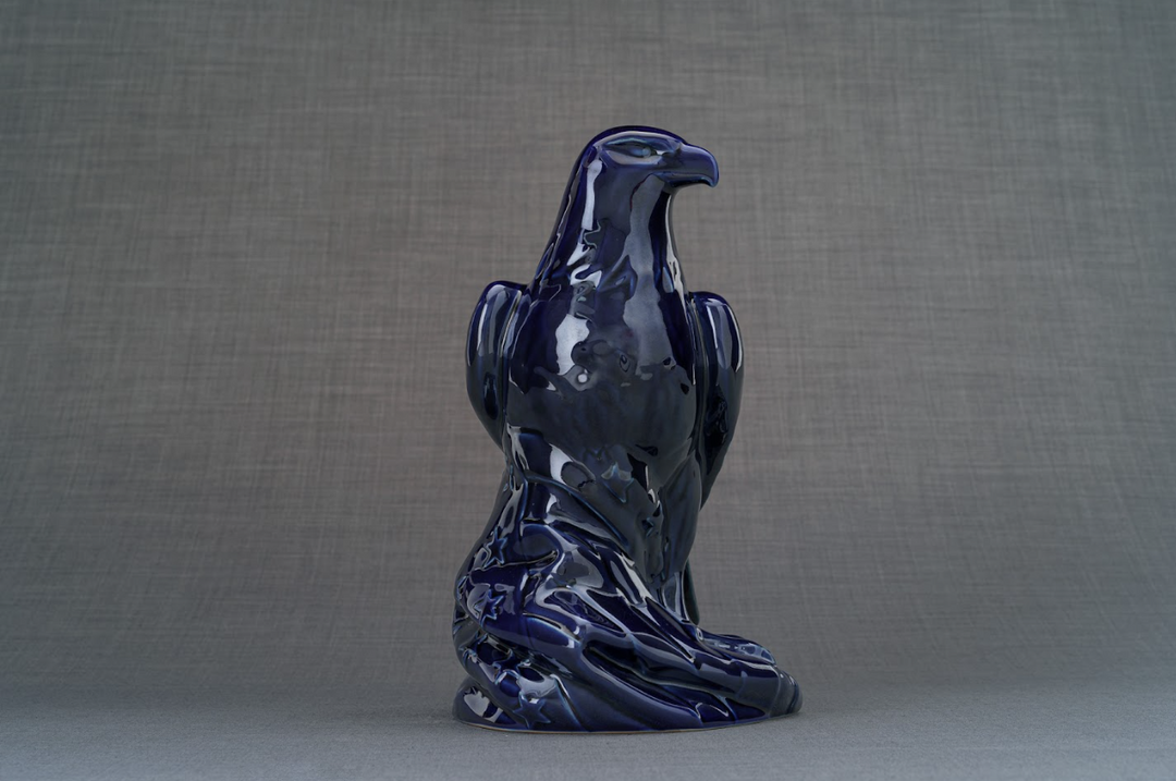 Deep blue Aquilae ceramic eagle urn viewed from behind with glossy finish and detailed feathers.