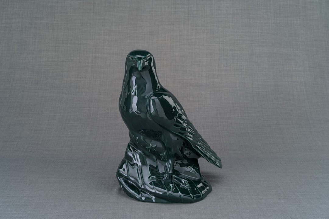 Aquilae dark green ceramic eagle urn with perched eagle on a rocky pedestal