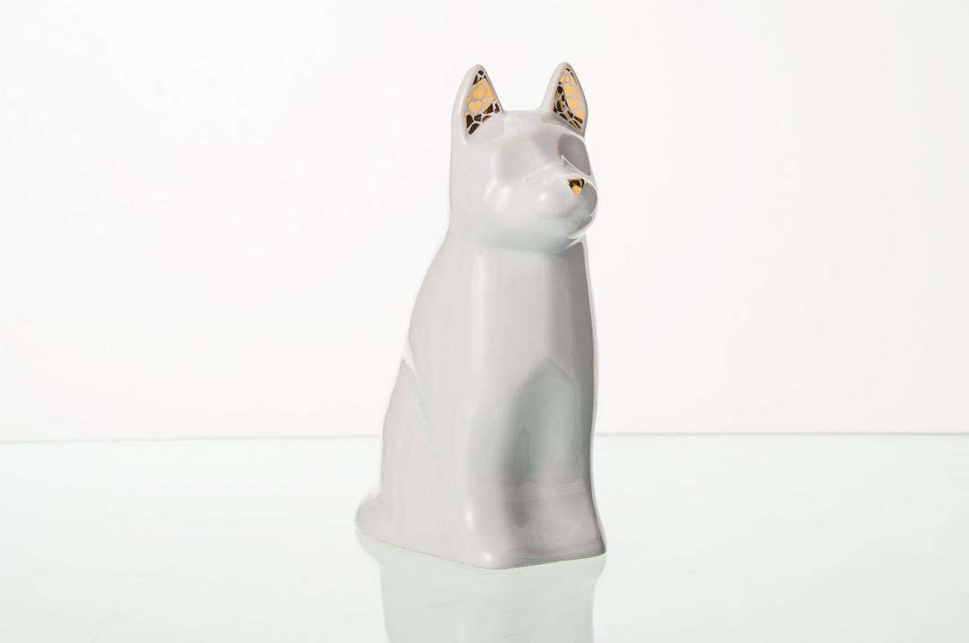 White Barkley Dog Ceramic Urn in a glossy finish with gold lattice ear accents on a reflective surface