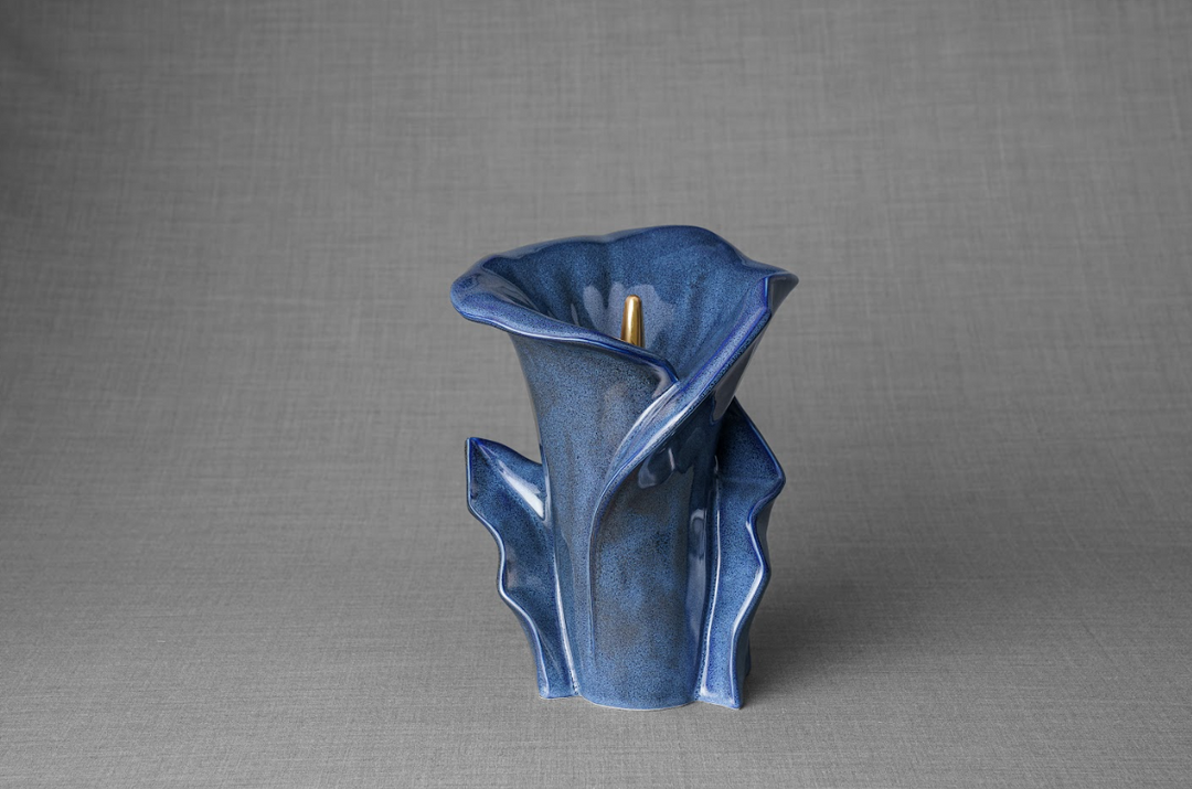 Cobalt blue glazed Calla Lily ceramic urn with sculpted petals and a gold stem, bottom filled.