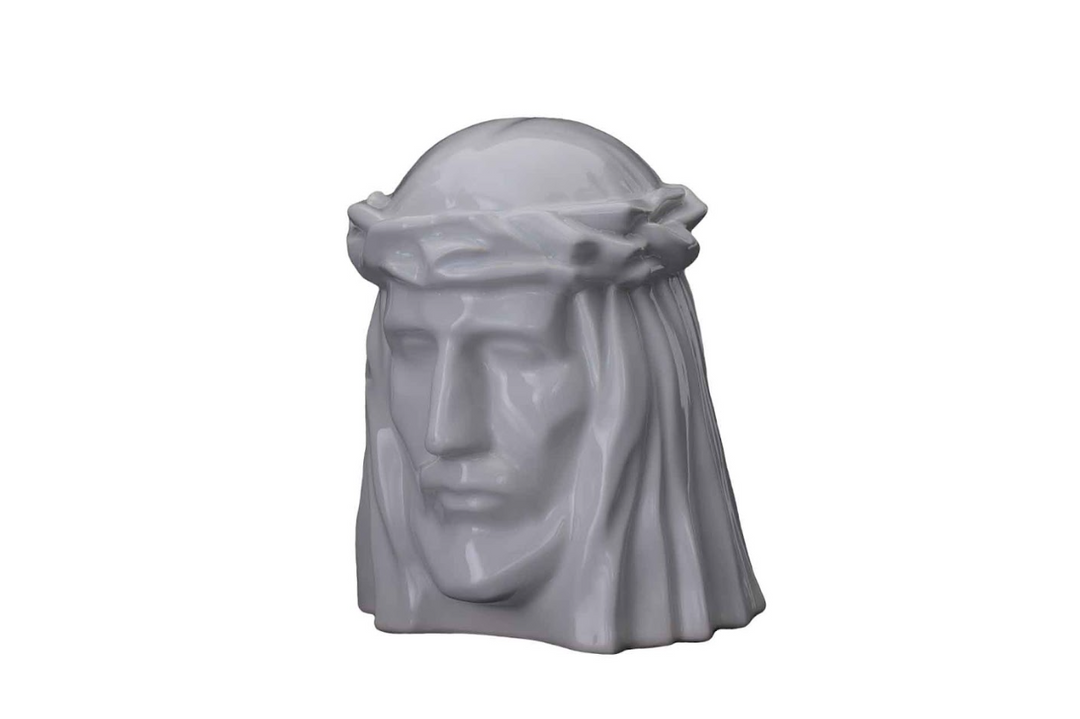 White ceramic bust of Christ with a crown of thorns, a serene devotional urn sculpture.