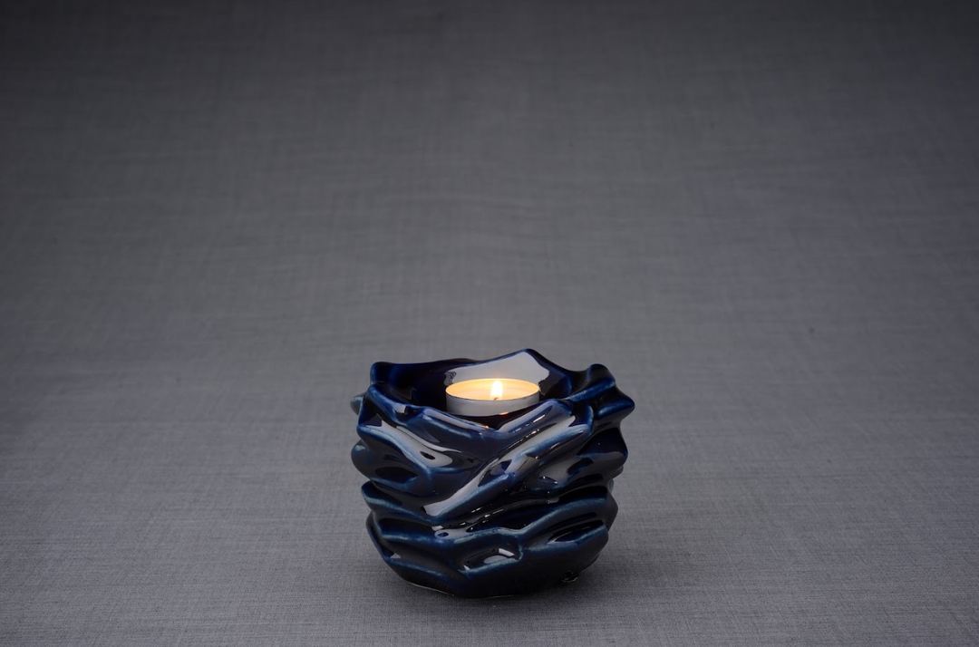 Blue glaze Christ Ceramic Urn with a lit tealight resting in the top opening.