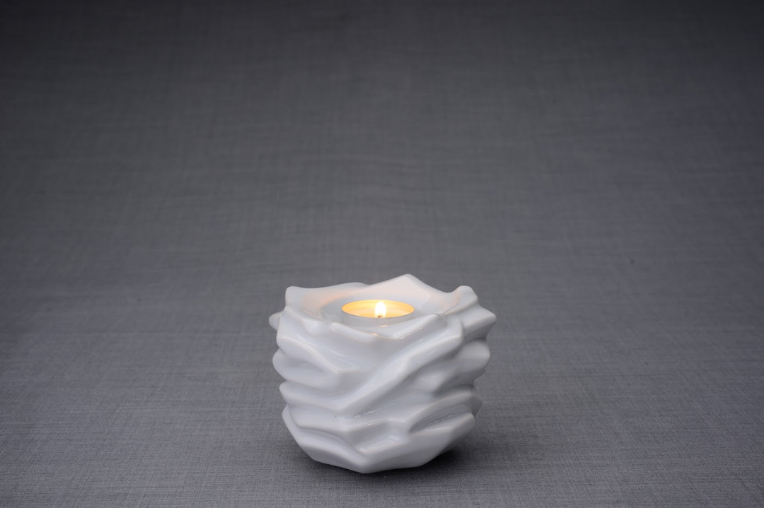 White Christ Ceramic Urn with a folded layered surface and a glowing tealight on top