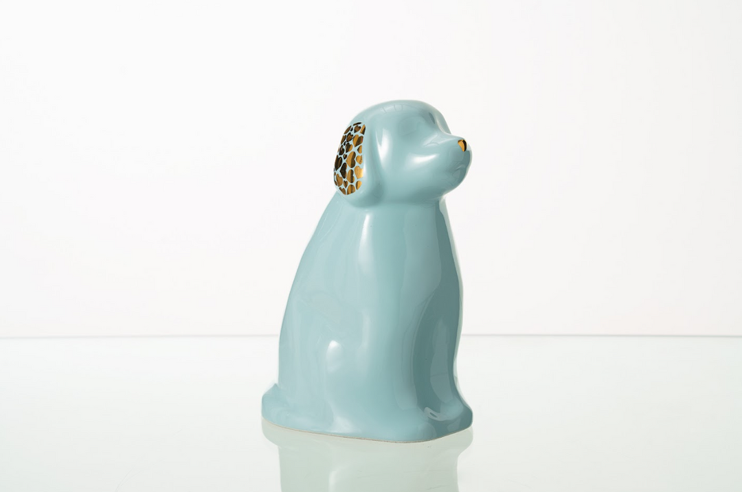 Light blue Cuddle Dog ceramic urn with gold honeycomb ear accents on a white studio surface.