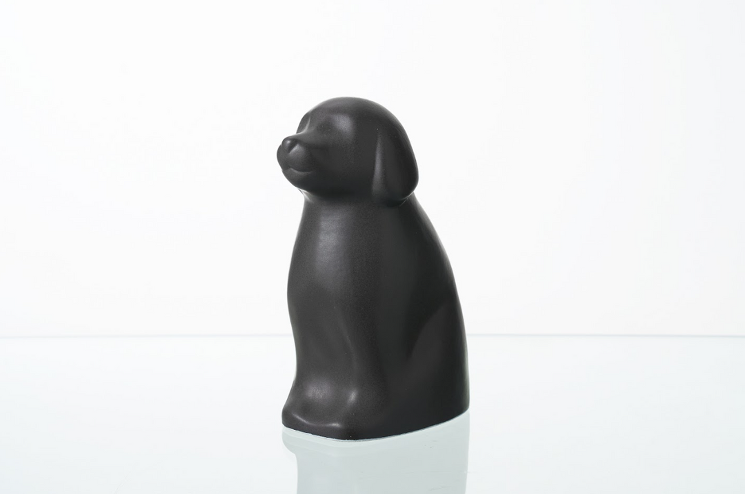Dark gray Cuddle Dog ceramic urn with smooth glossy finish on a white surface.