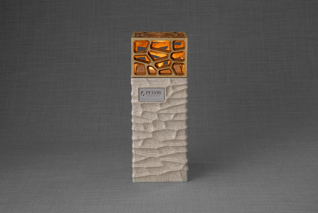Everlasting Flame ceramic urn with red textured base and gold lattice top enclosing a glowing candle.
