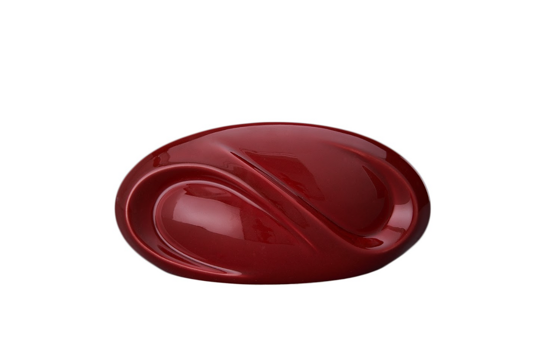 Deep red Eternity ceramic urn featuring fluid curves and a built in candle holder.