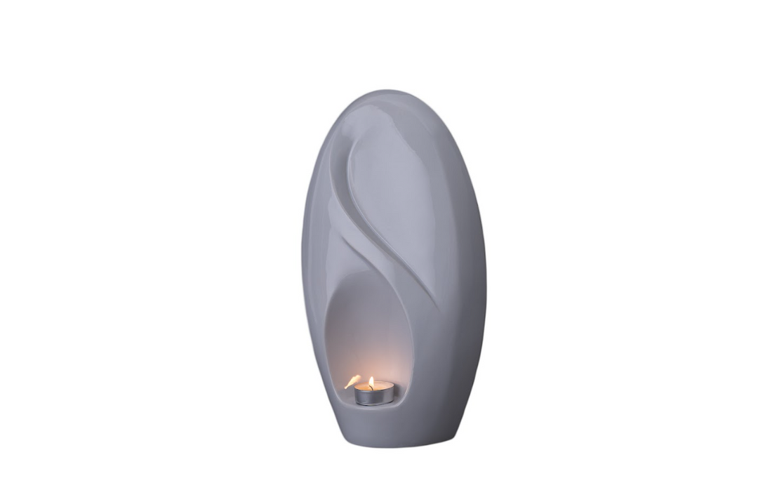 Eternity ceramic urn in soft gray with infinity inspired curves and a built-in candle holder.