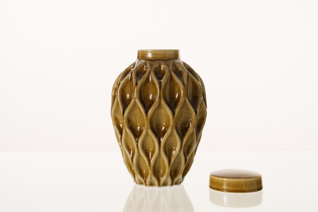 Bronze brown Echo ceramic urn with a tactile lattice motif and lid resting nearby.