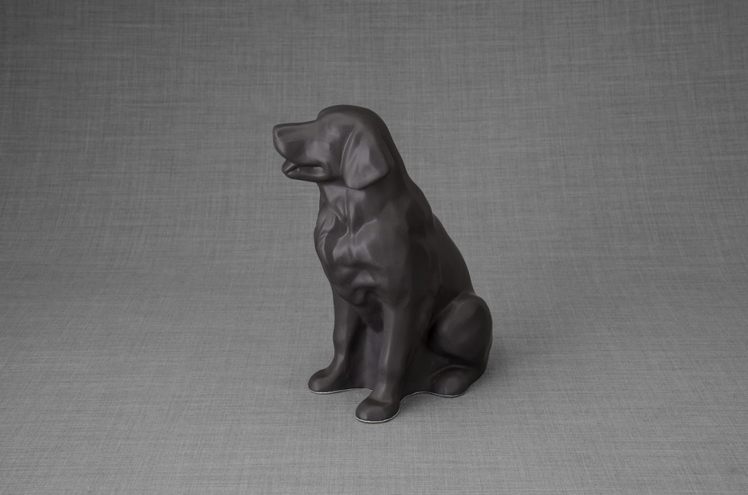 Dark gray ceramic Golden Retriever statue sitting on a gray surface