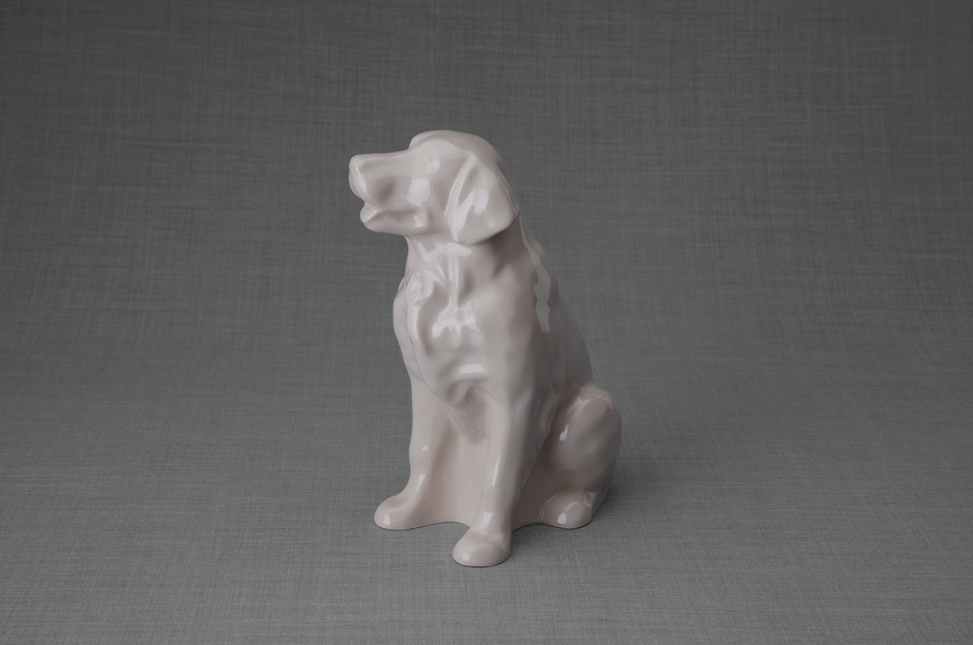 Beige ceramic Golden Retriever sculpture seated on a gray backdrop
