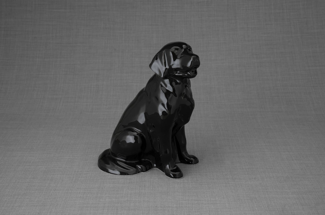 Glossy black ceramic dog statue posed on a neutral gray backdrop.