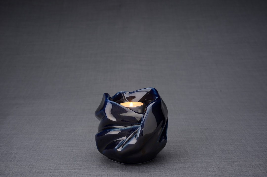 Blue glazed Holy Mother ceramic urn with a lit candle in the opening