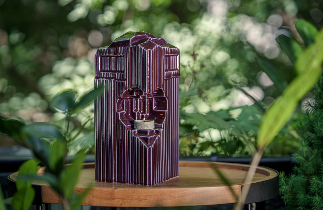 Purple ribbed Heart Ceramic Urn with a heart cutout candle holder on a wooden table outdoors.