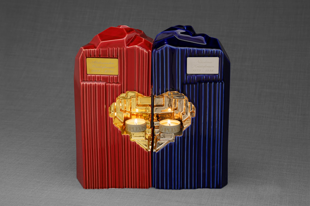 Red and blue Heart Ceramic Urns joined as a companion set with a gold heart centerpiece and two lit candles