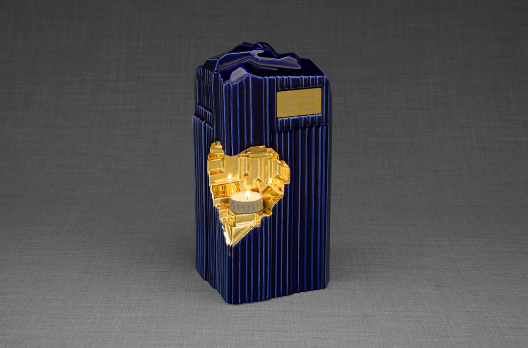 Blue ribbed Heart Ceramic Urn with a gold heart insert and lit candle, engraving plate on the front.