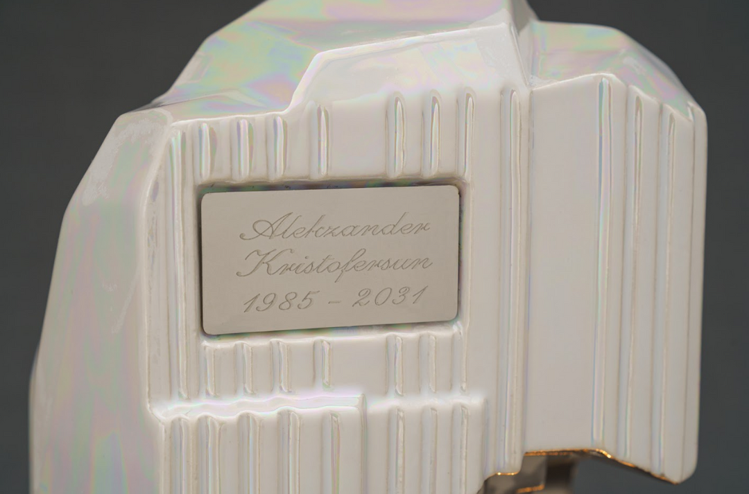Close-up of a glossy white ceramic keepsake with a recessed metal engraving plaque.