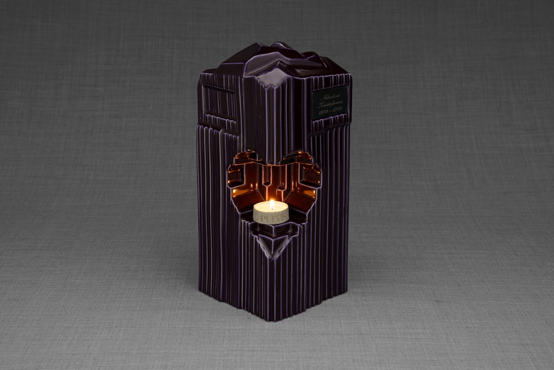 Deep purple ribbed Heart ceramic urn with a candle lit in the heart opening.