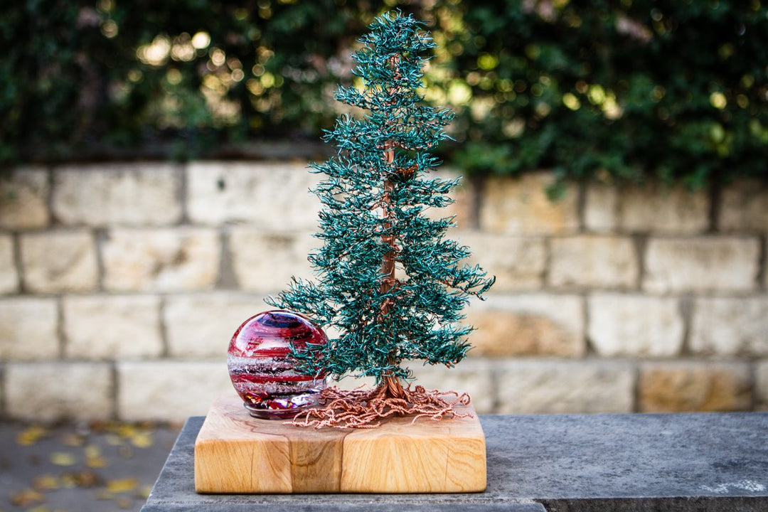 Teal Spruce Tree of Life on a sanded Cypress base with copper root detailing and a red glass orb beside the base.