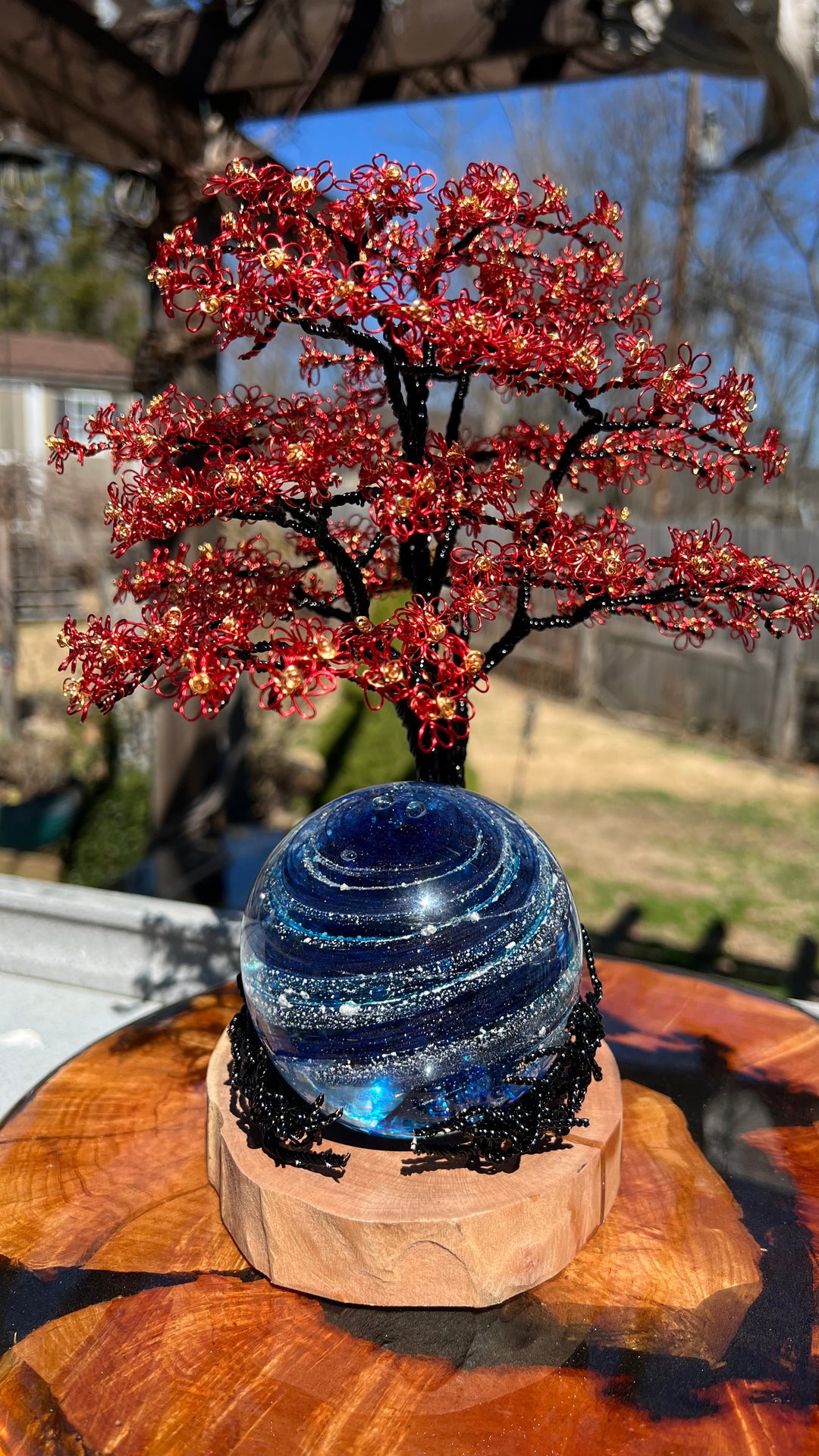 Flamboyant Tree of Life with red wire blossoms above a blue swirling Sparkle Orb on a wooden base