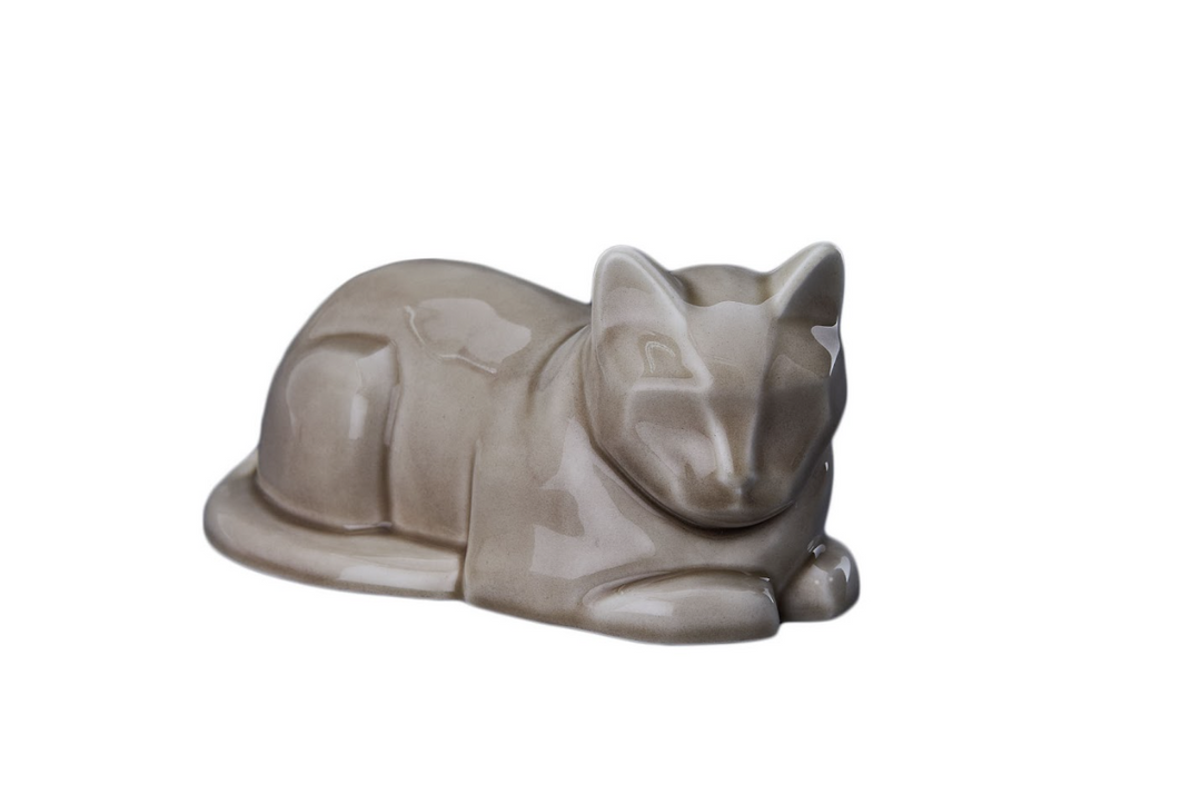 Beige sleeping cat ceramic urn with a crackled glaze against a white backdrop