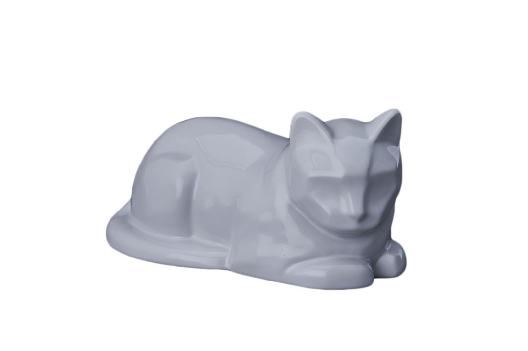 Lying cat ceramic urn in glossy white, a serene resting feline sculpture.
