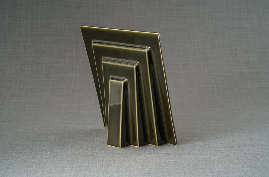 Set of nested rectangular picture frames in a dark olive glaze arranged upright on a gray backdrop.