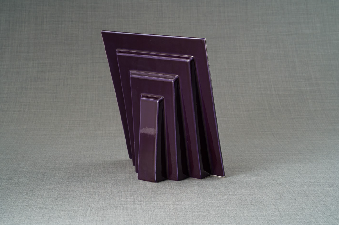 Back view of nested purple picture frames in four sizes standing on a gray surface.