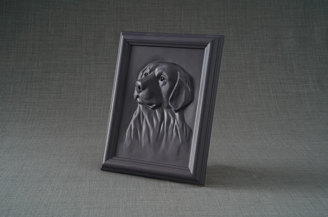 Dark gray framed ceramic relief of a Labrador retriever against a textured gray backdrop.