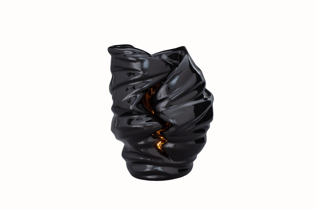Glossy black Light Ceramic Urn with a sculptural twisted interior and a lit candle inside.