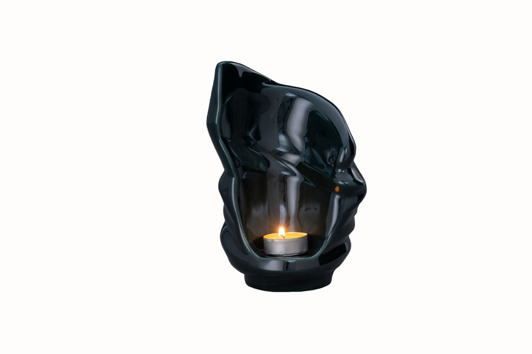 Charcoal Light Ceramic Urn candle holder with tealight glowing inside the hollow sculpture.