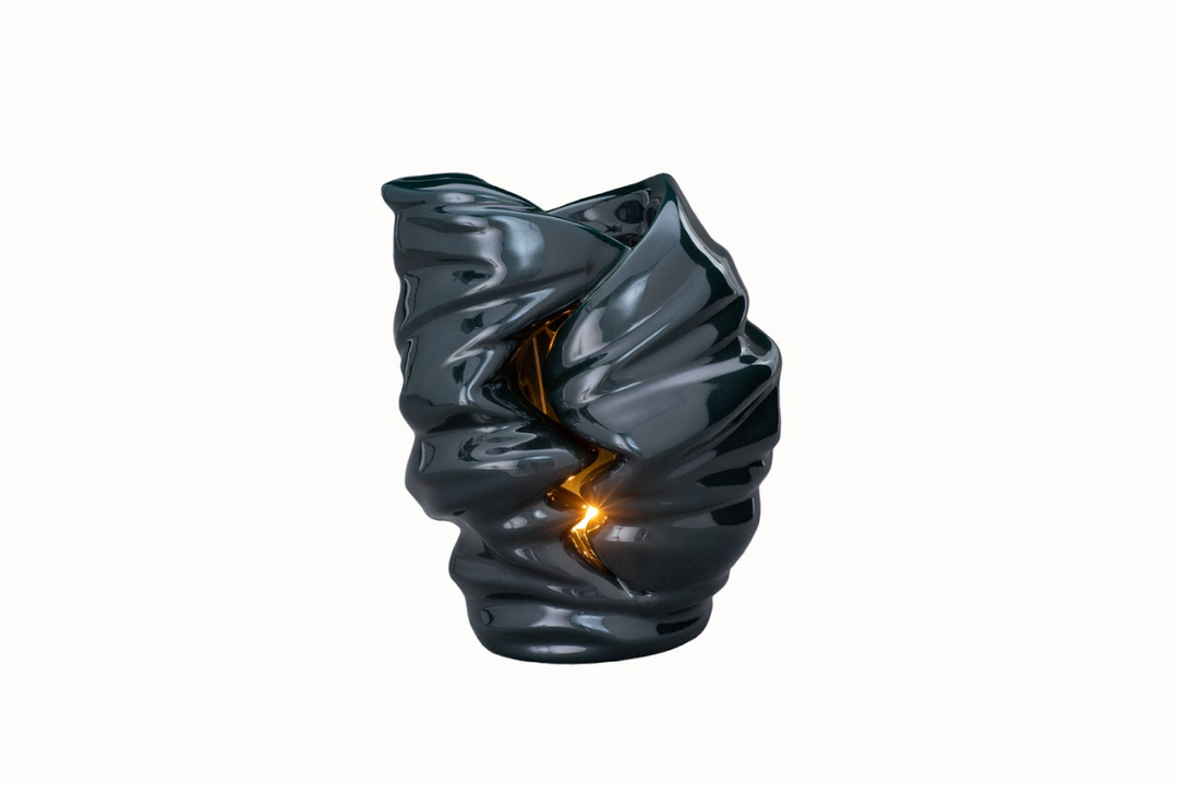 Dark glazed Light Ceramic Urn candle holder with a warm flame visible through the opening.
