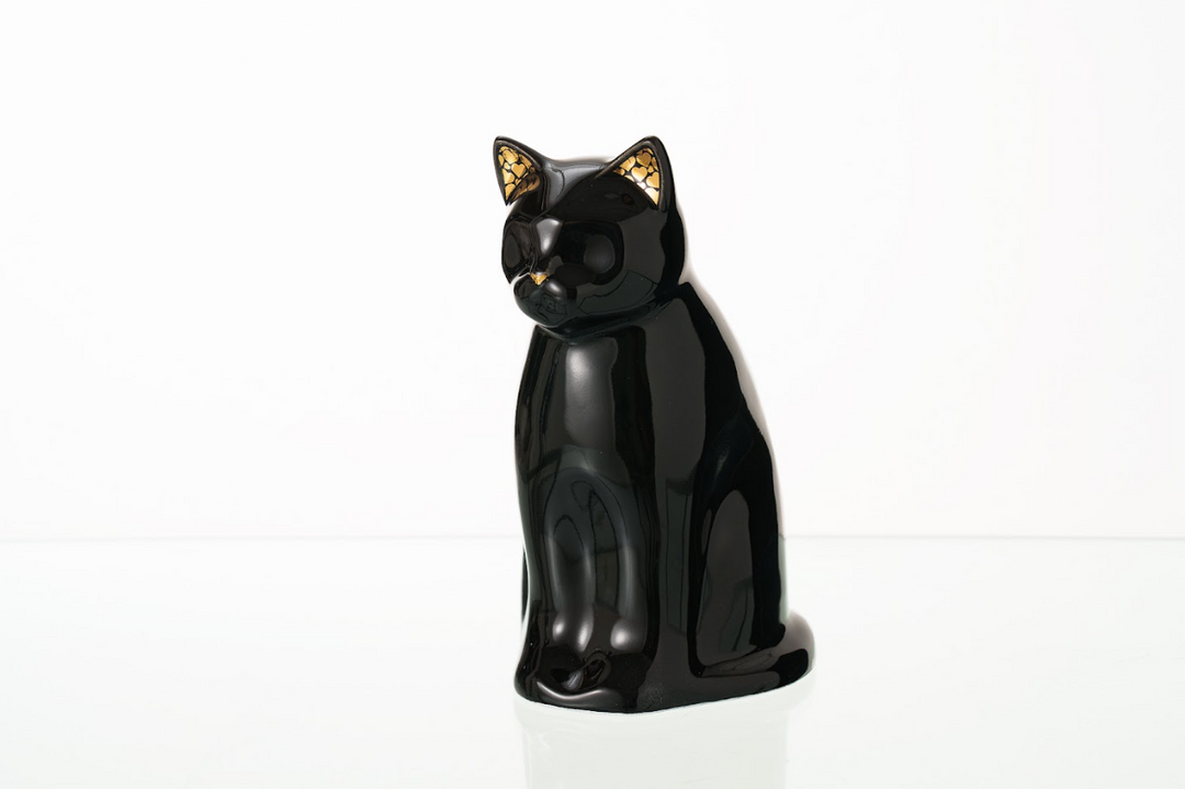 Glossy black Meow cat ceramic urn with gold patterned ears on a white background