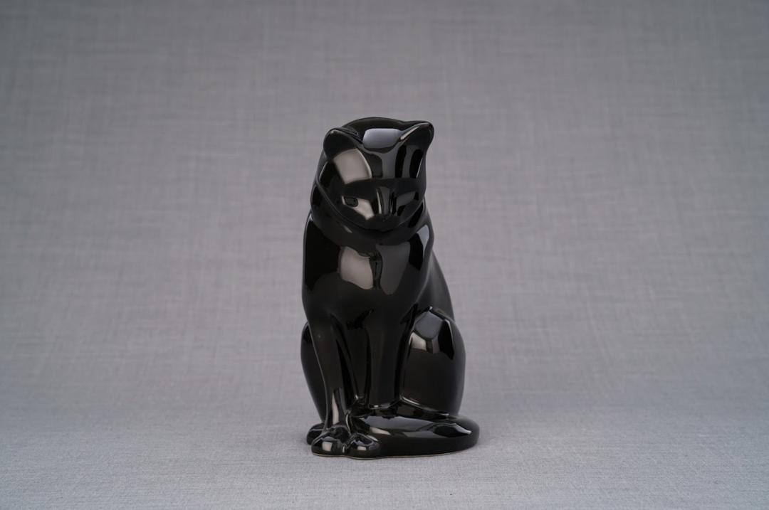 Front-facing glossy black ceramic cat urn in a seated pose