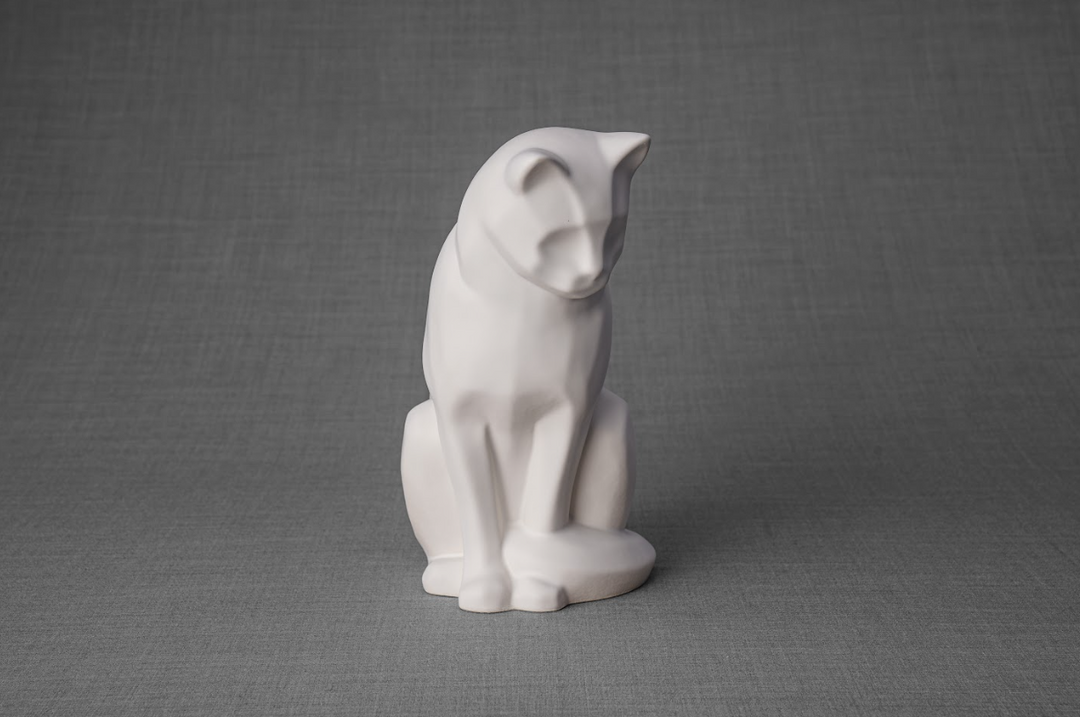White glossy ceramic cat urn in a seated pose against a neutral gray backdrop.