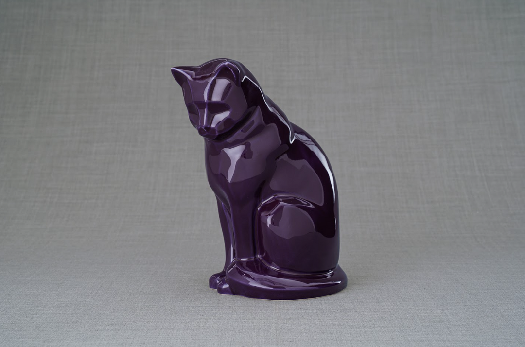 Neko cat ceramic urn in glossy purple, stylized sitting cat on a round base.