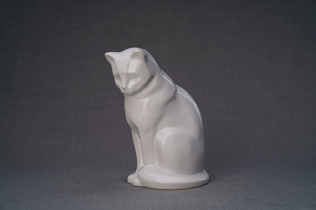 White glossy ceramic cat urn in a seated pose on a plain gray background.