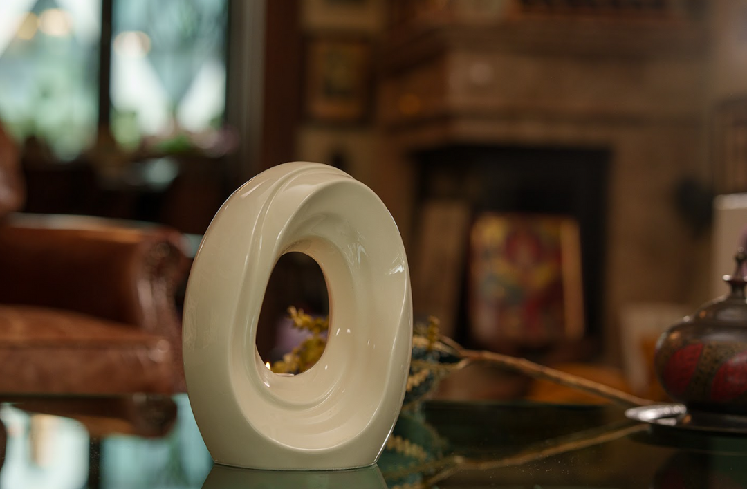 Blue abstract ceramic sculpture with nested circular forms and a candle lit in the center