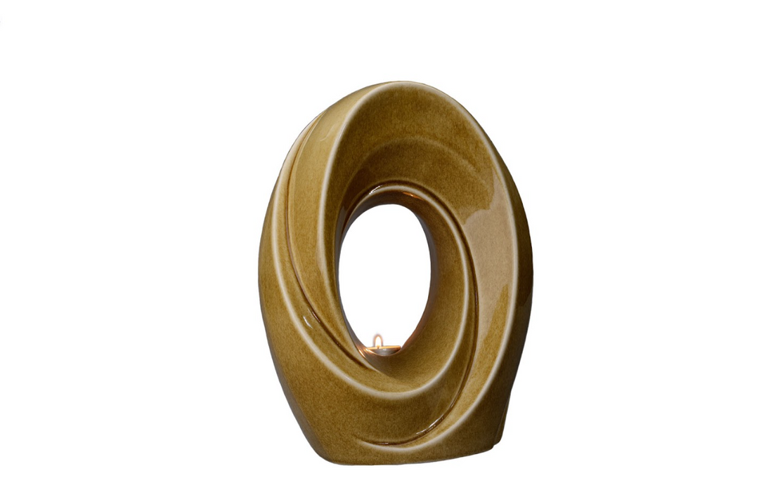 Brown glazed ceramic urn with a circular center and built in candle holder showing a small candle inside.