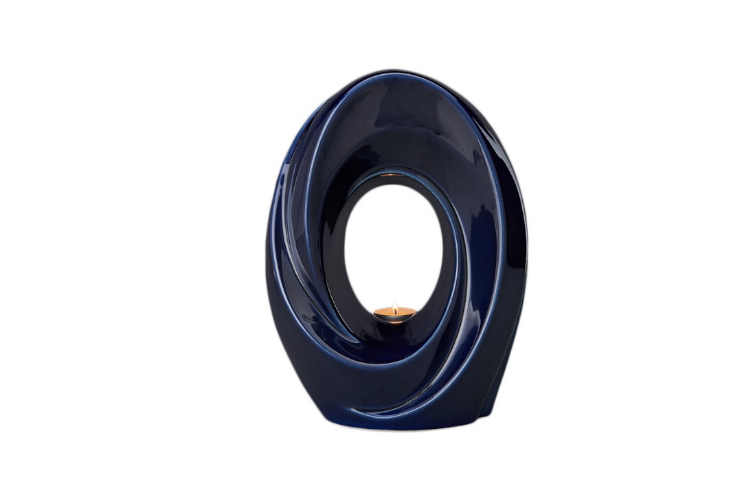 Deep blue swirl ceramic candle holder with a circular opening and a small flame in the center