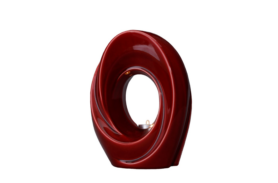 Red The Passage ceramic urn with a glossy swirling spiral and hollow center.